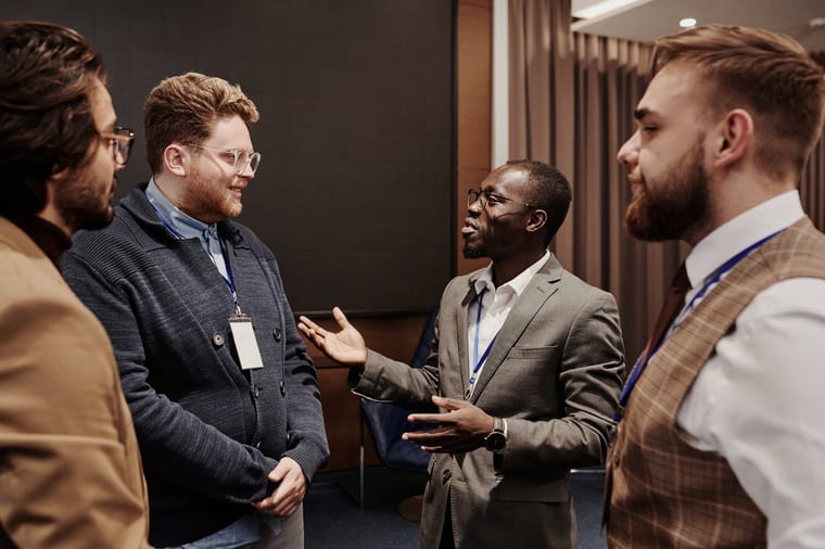 Four business professionals talking at a networking event