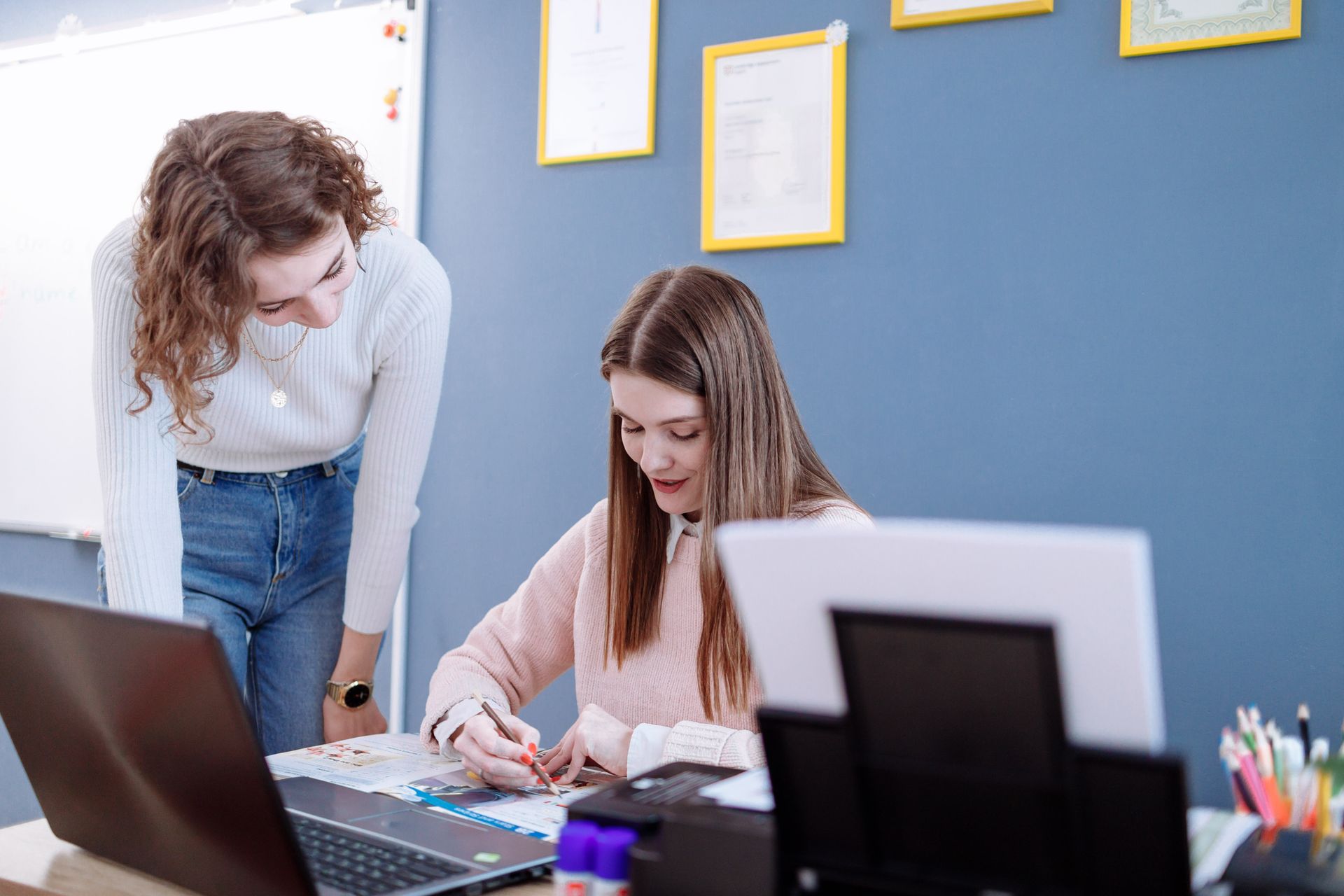 Two people reviewing documents at a computer